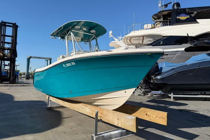 Slide: The Image of 2018 Cobia 220 Center Console boat on display at a marina. - 3
