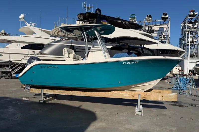 Slide: The Image of 2018 Cobia 220 Center Console boat on display at a marina. - 4