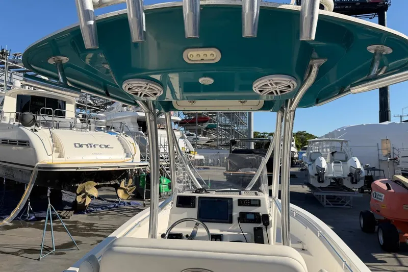 Slide: The Image of 2018 Cobia 220 Center Console boat in a marina with other vessels. - 6