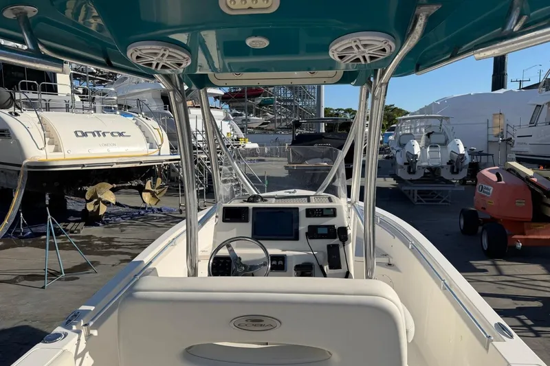 Slide: The Image of 2018 Cobia 220 Center Console boat interior at a marina with surrounding vessels. - 7