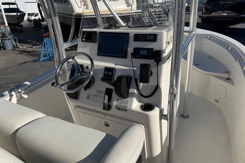 Slide: The Image of 2018 Cobia 220 Center Console boat dashboard with steering wheel and navigation equipment. - 8