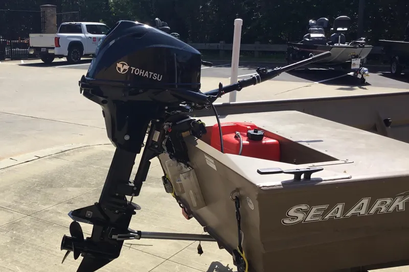 The Image of 2024 SeaArk 1448 MV boat with Tohatsu outboard motor in a parking lot. - 2