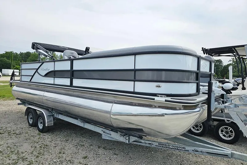 Slide: The Image of 2026 Bentley Pontoons 243 FNC Fish N Cruise on trailer, sleek design, outdoor setting. - 2