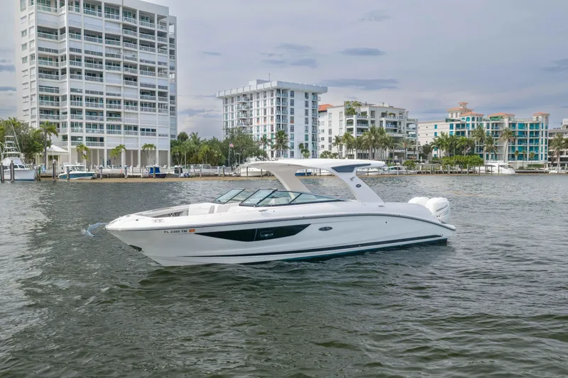 The Image of 2023 Sea Ray SLX 350 Outboard boat cruising near waterfront buildings. - 1