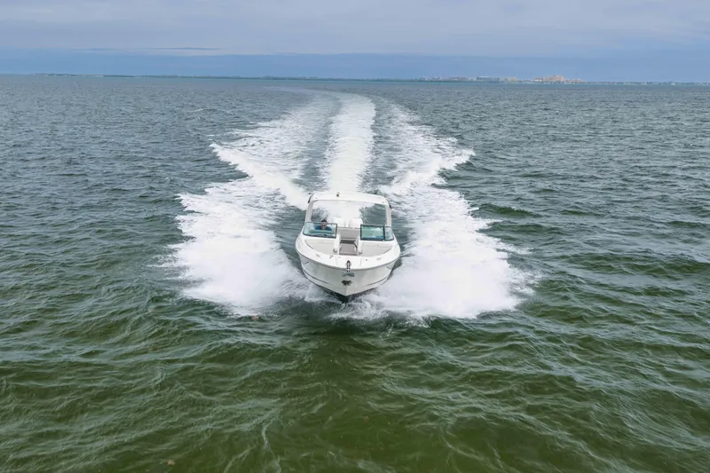 Slide: The Image of 2023 Sea Ray SLX 350 Outboard cruising on open water, leaving a wake trail. - 18