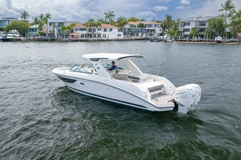 Slide: The Image of 2023 Sea Ray SLX 350 Outboard cruising near waterfront homes. - 5