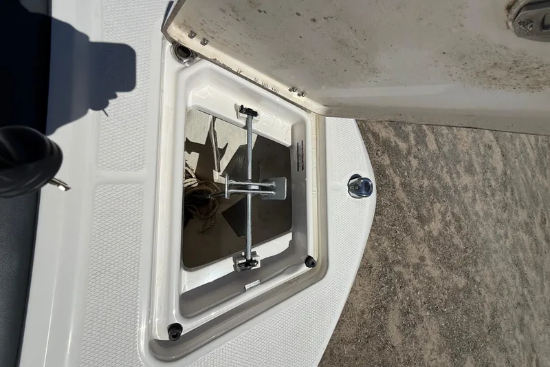 Slide: The Image of Open anchor compartment on 2023 Robalo R202 Explorer boat, showing anchor and rope storage. - 11