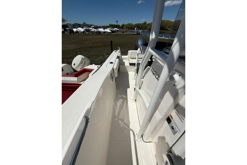 Slide: The Image of 2023 Robalo R202 Explorer boat interior with seating and railing, parked outdoors. - 20