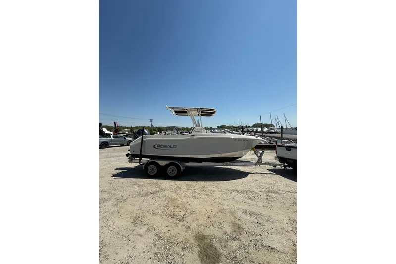 Slide: The Image of 2023 Robalo R202 Explorer boat on trailer under clear blue sky. - 3
