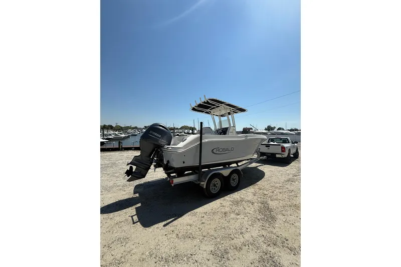 Slide: The Image of 2023 Robalo R202 Explorer boat on trailer, parked outdoors under clear blue sky. - 4