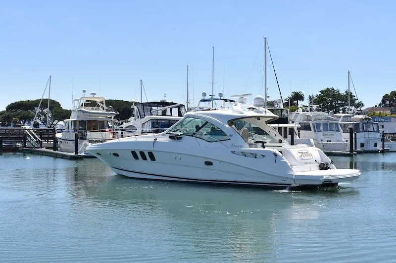 Slide: The Image of 2007 Sea Ray 48 Sundancer yacht docked in marina, surrounded by boats. - 1