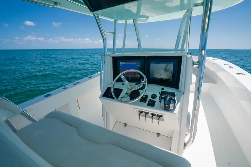 Slide: The Image of 2006 Venture 39 Open boat helm with dual screens, steering wheel, and ocean view. - 21