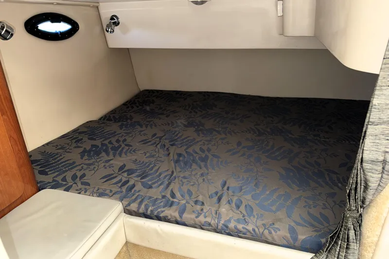 Slide: The Image of 2005 Regal Commodore 2665 cabin interior with patterned bedding and small window. - 15