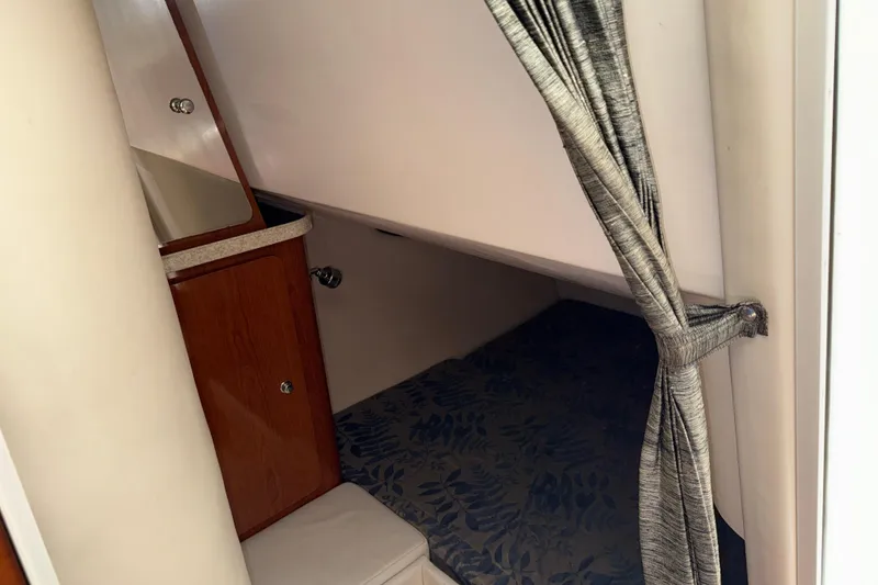 Slide: The Image of 2005 Regal Commodore 2665 cabin interior with curtain and wooden cabinet. - 17