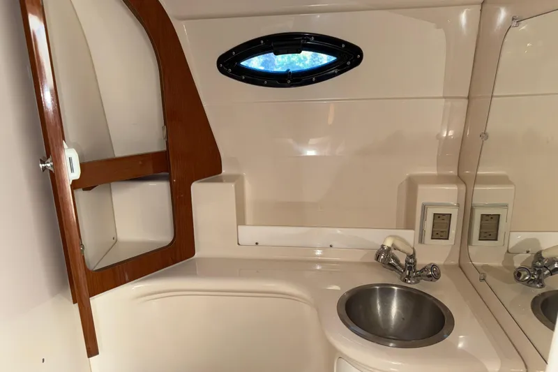 Slide: The Image of 2005 Regal Commodore 2665 boat bathroom with sink, mirror, and wooden cabinet. - 20