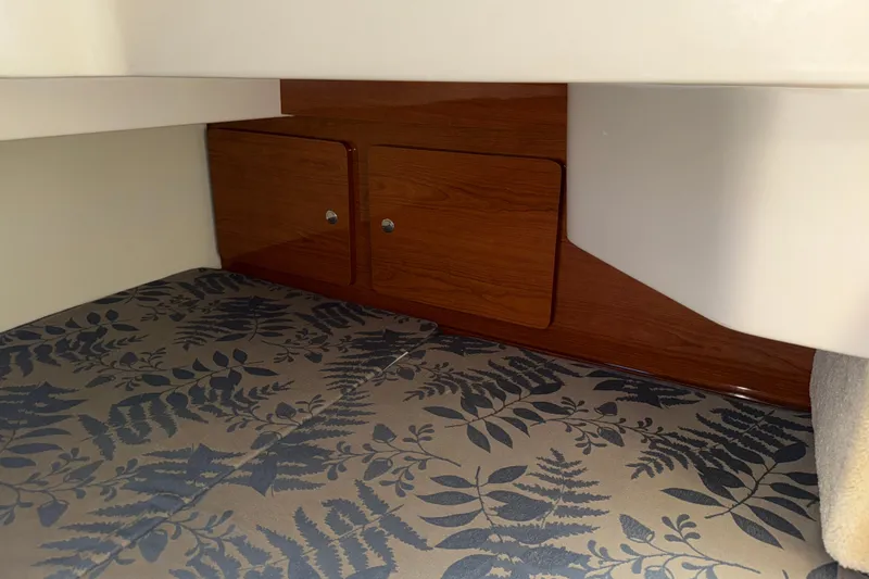 Slide: The Image of Interior cabin of 2005 Regal Commodore 2665 with floral-patterned upholstery and wooden storage cabinets. - 26
