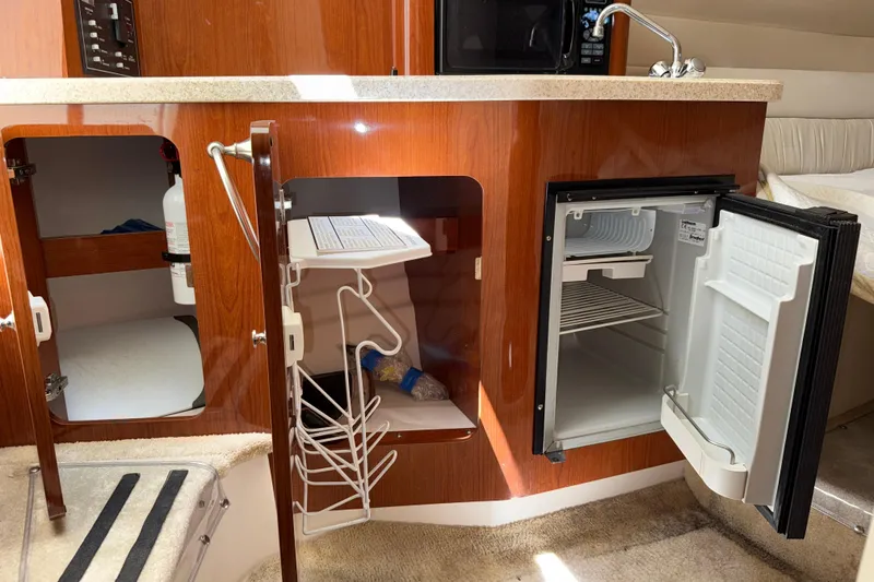 Slide: The Image of 2005 Regal Commodore 2665 yacht interior with kitchenette, fridge, and storage cabinets. - 27