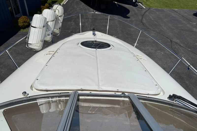 Slide: The Image of 2005 Regal Commodore 2665 boat deck with hatch and railing, parked on pavement. - 35