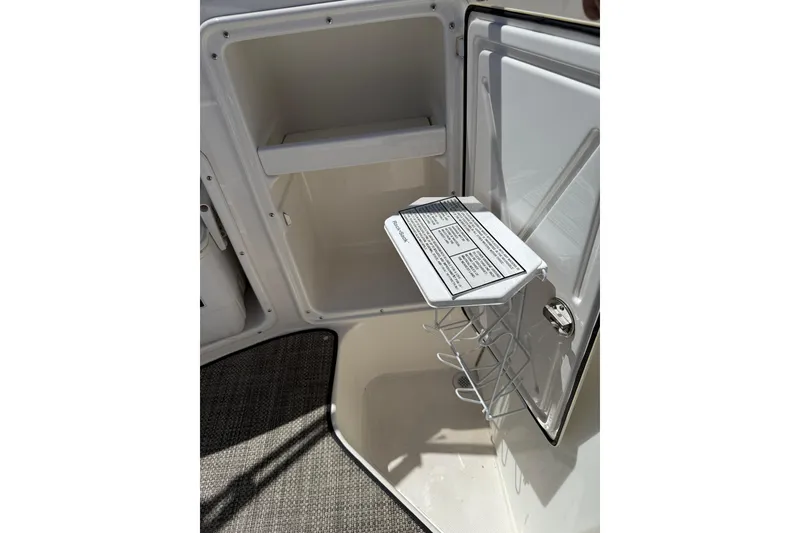 Slide: The Image of Open storage compartment in 2005 Regal Commodore 2665 boat, featuring interior shelving and door rack. - 36