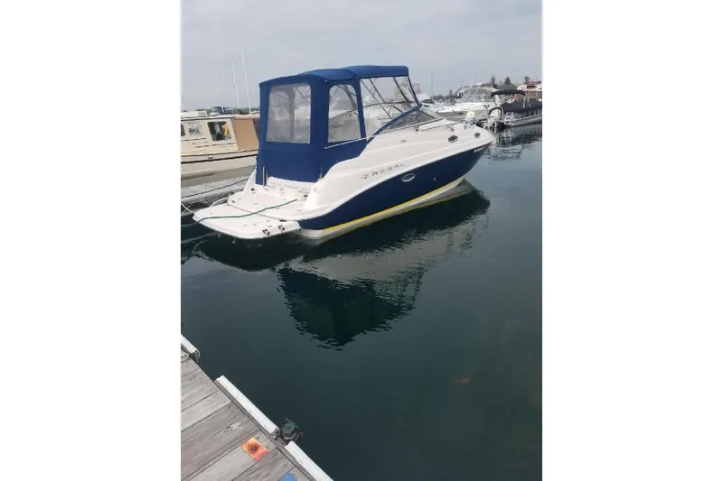 Slide: The Image of 2005 Regal Commodore 2665 boat docked in marina with blue canopy. - 40