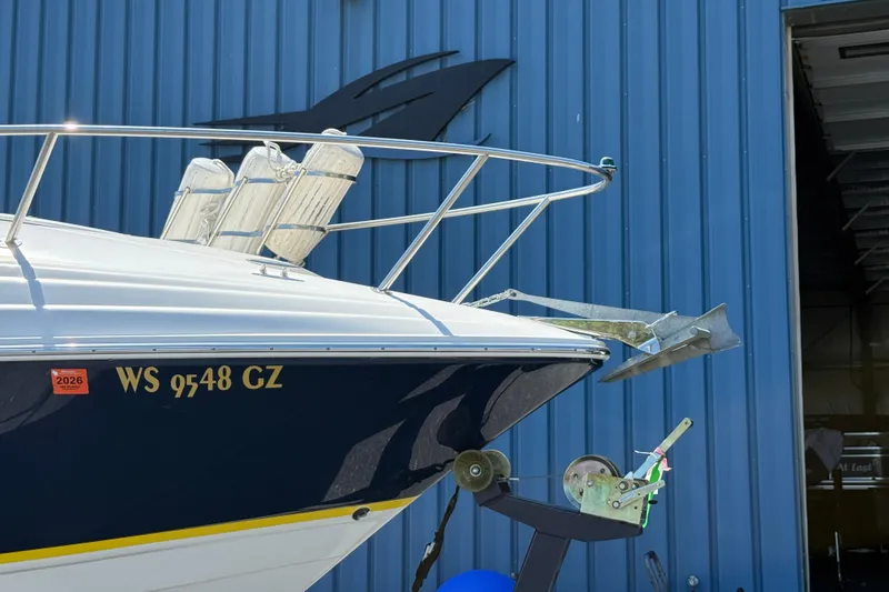 Slide: The Image of 2005 Regal Commodore 2665 boat with anchor, docked near blue building. - 9