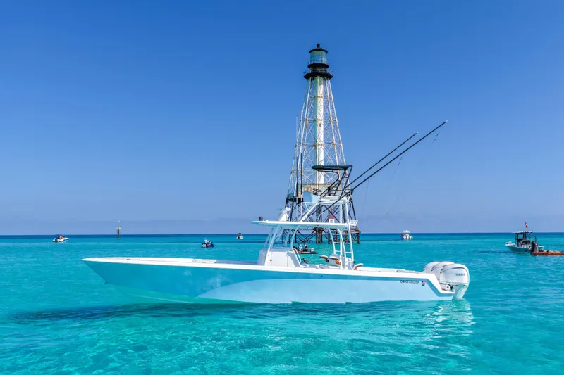 The Image of 2026 Contender 39 ST boat in clear blue waters near a lighthouse. - 0