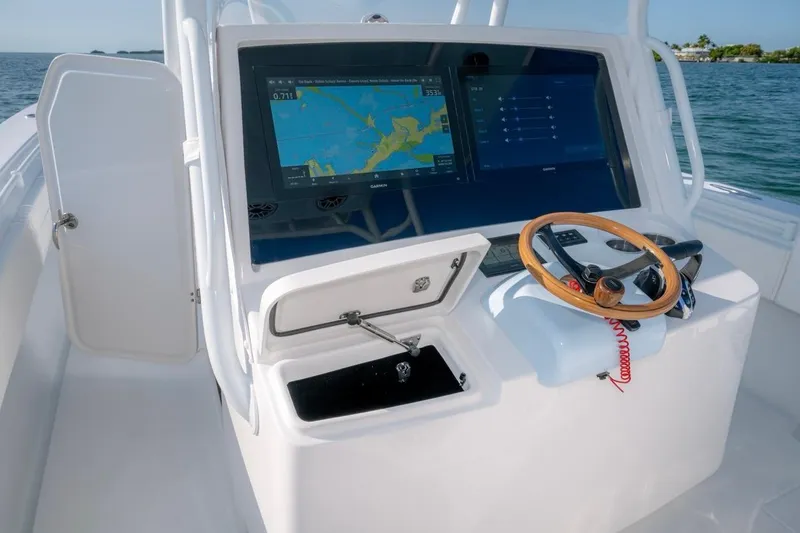 Slide: The Image of 2026 Contender 39 ST boat dashboard with navigation display and steering wheel. - 10