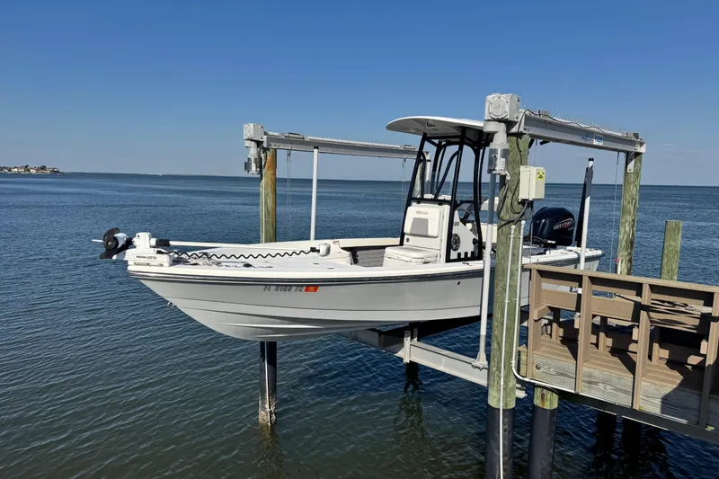 The Image of 2022 Pathfinder 2400 TRS boat on lift over calm water, clear blue sky. - 1