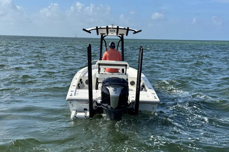 Slide: The Image of 2022 Pathfinder 2400 TRS boat navigating open waters under clear skies. - 16