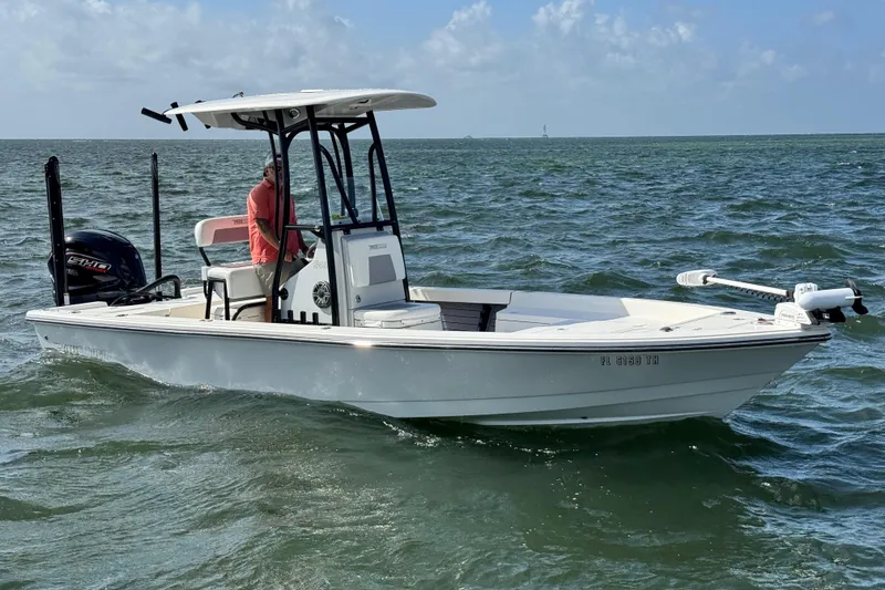 Slide: The Image of 2022 Pathfinder 2400 TRS boat on lift over calm water, clear blue sky. - 18