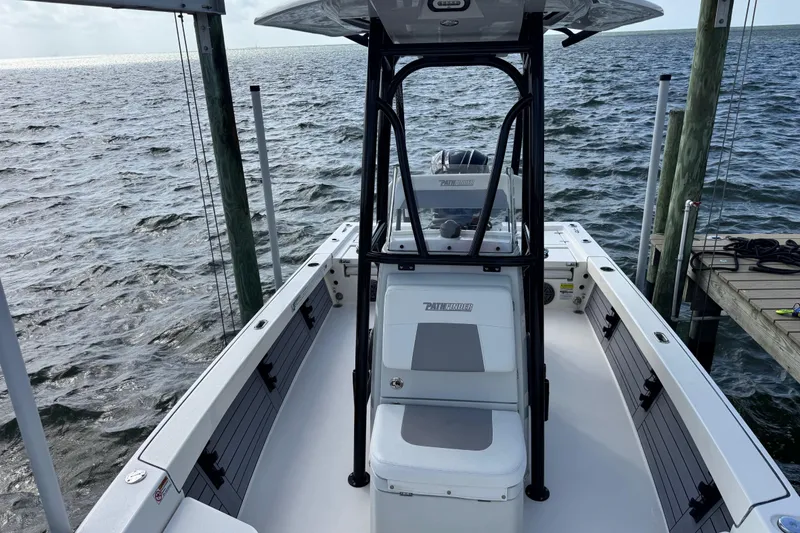 Slide: The Image of 2022 Pathfinder 2400 TRS boat docked on a calm sea, showcasing sleek design and spacious deck. - 35