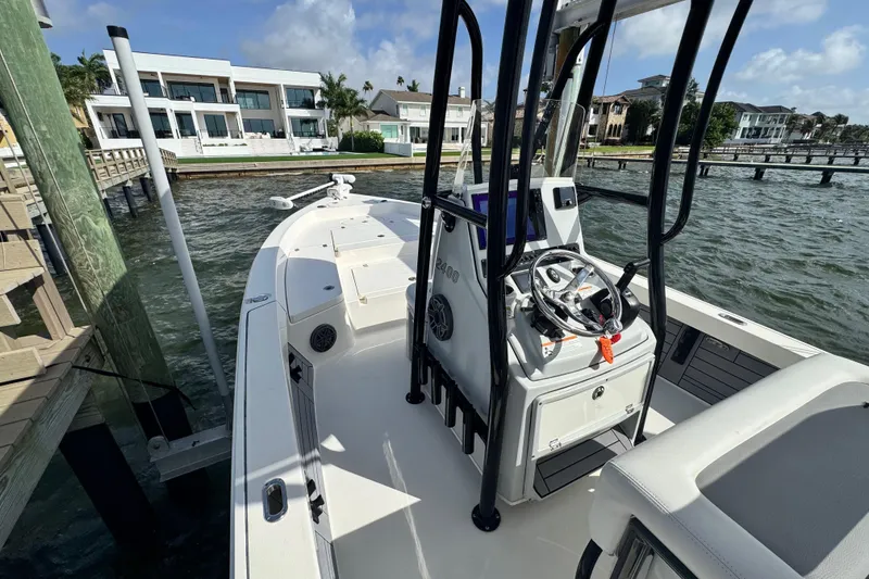 Slide: The Image of 2022 Pathfinder 2400 TRS boat docked by waterfront homes under a clear sky. - 40