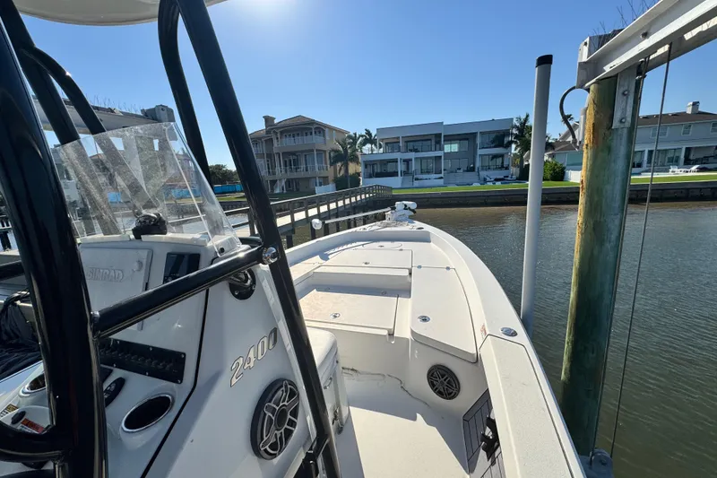 Slide: The Image of 2022 Pathfinder 2400 TRS boat docked by waterfront homes under clear blue sky. - 5
