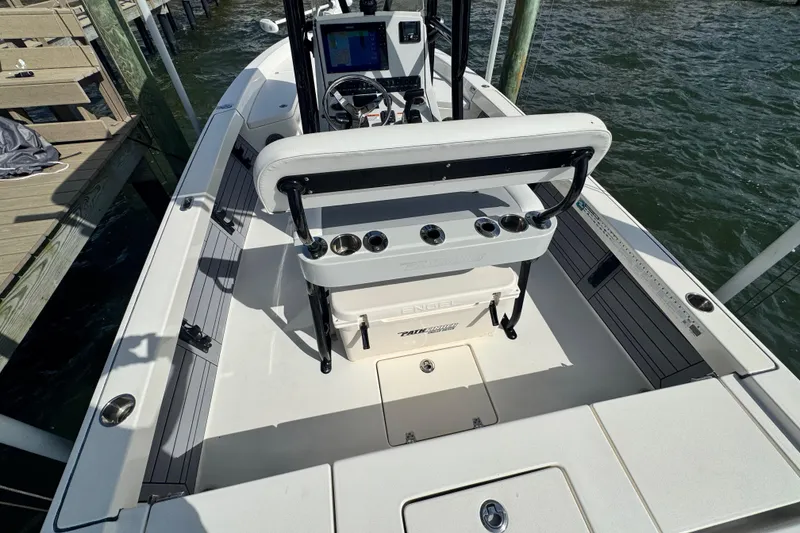 Slide: The Image of 2022 Pathfinder 2400 TRS boat interior with console and seating, docked by water. - 52