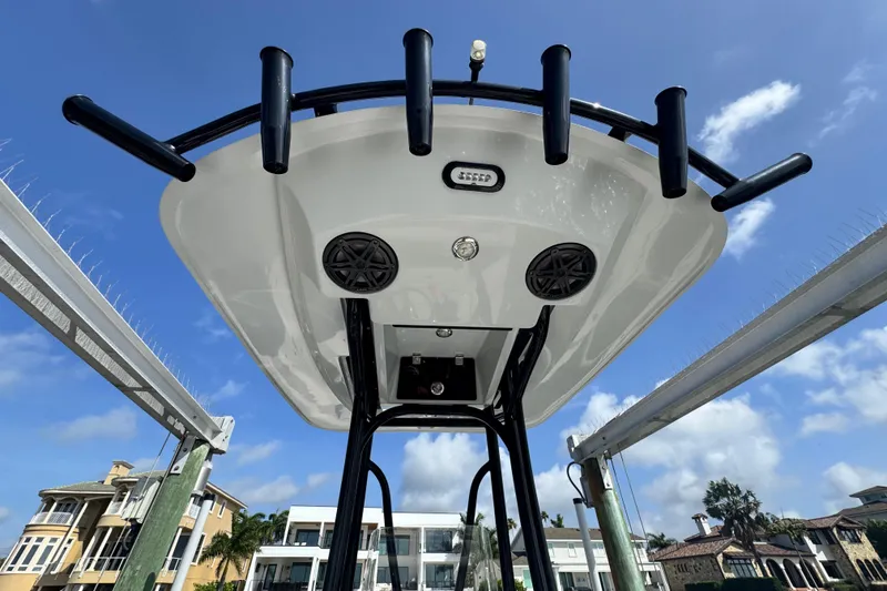 Slide: The Image of 2022 Pathfinder 2400 TRS boat T-top with rod holders and speakers, under a clear blue sky. - 54