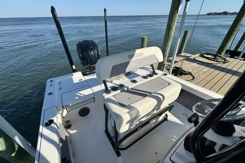Slide: The Image of 2022 Pathfinder 2400 TRS boat docked, featuring seating and outboard motor, with ocean view. - 7