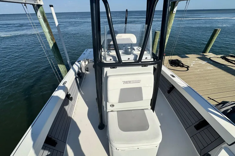 Slide: The Image of 2022 Pathfinder 2400 TRS boat docked by the ocean, showcasing sleek design and spacious deck. - 9