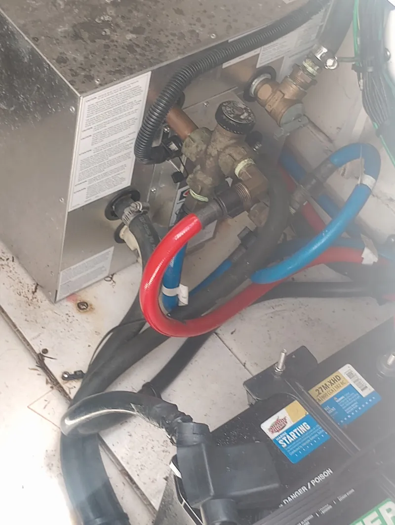Slide: The Image of 2005 Sea Ray 270 Amberjack engine compartment with hoses and battery. - 33