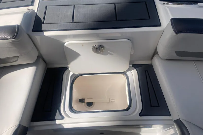 Slide: The Image of 2023 Hurricane SunDeck 235 OB boat storage compartment with open hatch, showcasing interior space. - 11