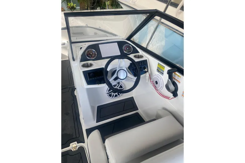 Slide: The Image of 2023 Hurricane SunDeck 235 OB boat cockpit with steering wheel and control panel. - 12