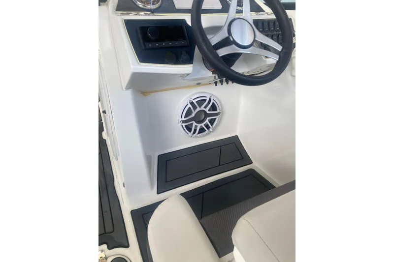 Slide: The Image of 2023 Hurricane SunDeck 235 OB boat interior with steering wheel and speaker. - 13
