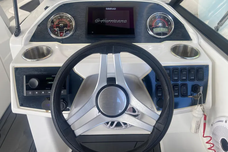 Slide: The Image of 2023 Hurricane SunDeck 235 OB boat dashboard with steering wheel and control panel. - 16
