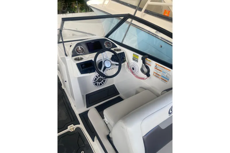 Slide: The Image of 2023 Hurricane SunDeck 235 OB boat cockpit with steering wheel and control panel. - 20