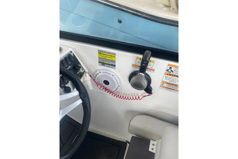 Slide: The Image of 2023 Hurricane SunDeck 235 OB boat dashboard with steering wheel and control panel. - 32