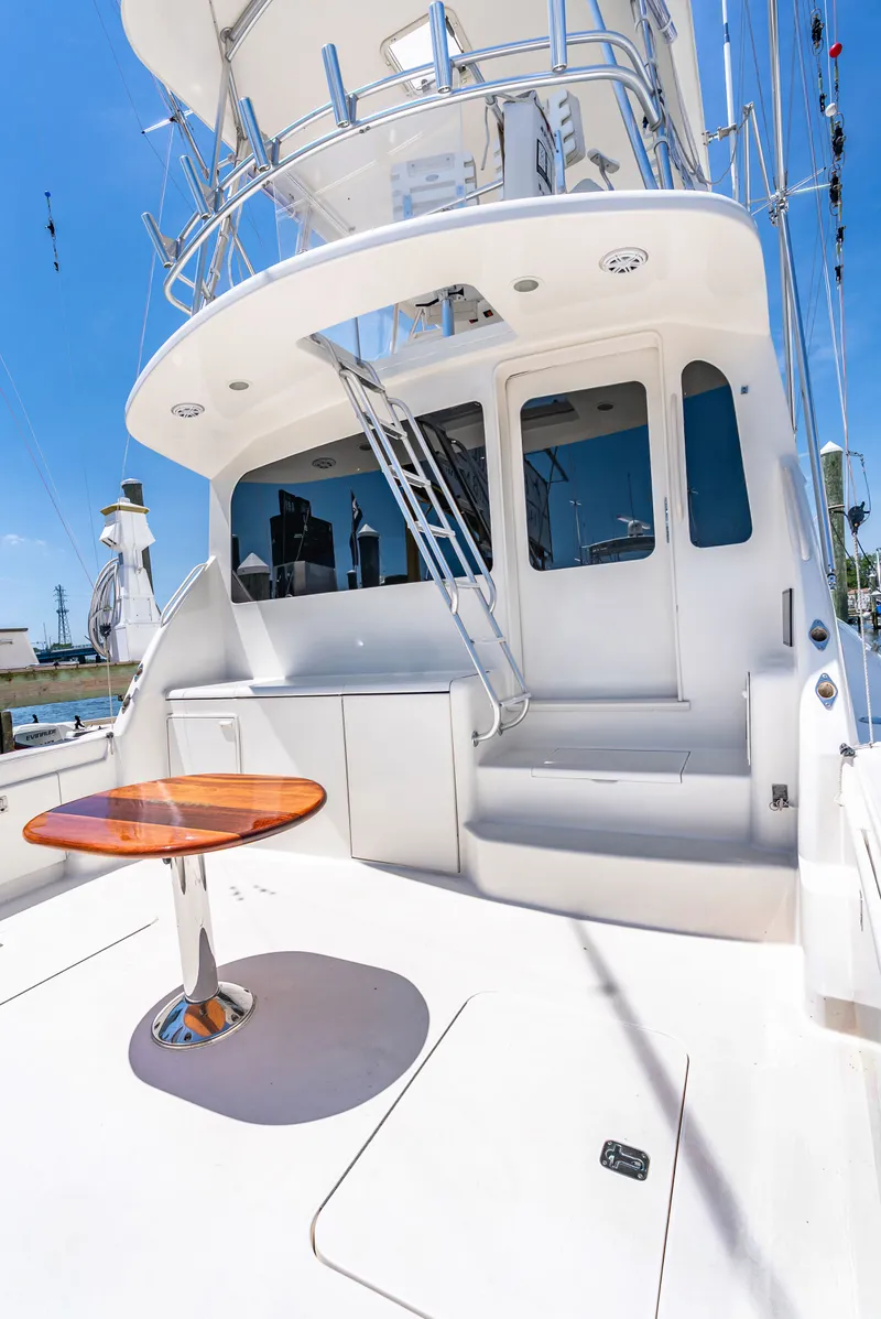 Slide: The Image of A luxurious yacht with a sleek white deck and a round wooden table outdoors. - 15