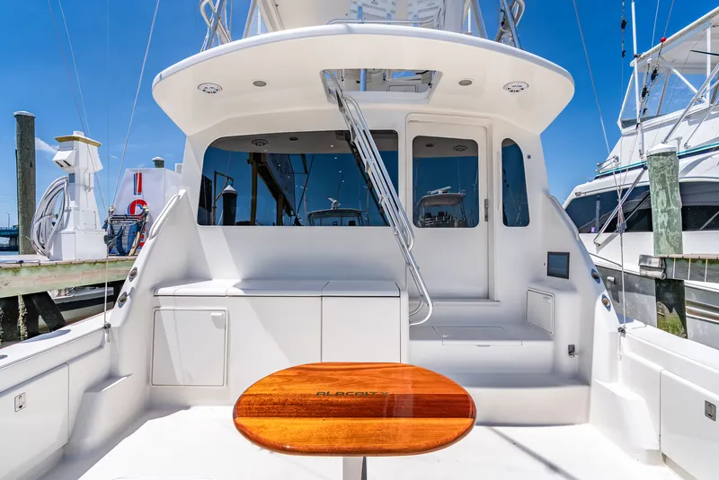 Slide: The Image of The image shows the stern of a 2004 Ocean Yachts 50 Convertible with a sleek wooden table. - 17