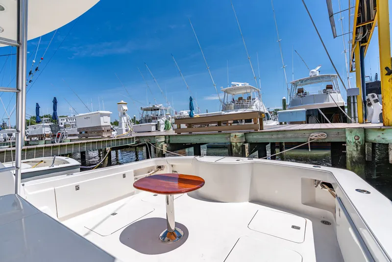 Slide: The Image of The deck of a 2004 Ocean Yachts 50 Convertible in a marina, surrounded by other boats. - 21