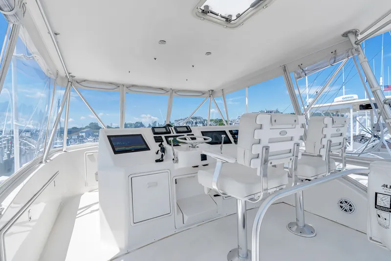 Slide: The Image of The cockpit of a 2004 Ocean Yachts 50 Convertible with white seating and modern electronics. - 25