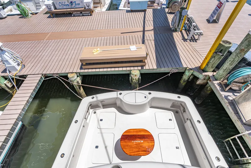 Slide: The Image of The image shows the stern of a boat docked at a pier. There's a large platform and wooden deck. - 43