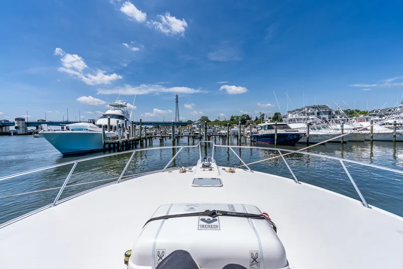 Slide: The Image of View from the bow of a yacht towards a marina with several boats under a blue sky. - 45